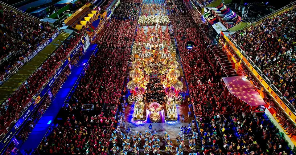 The Sambódromo avenue seen from above during a parade, packed grandstands on both sides